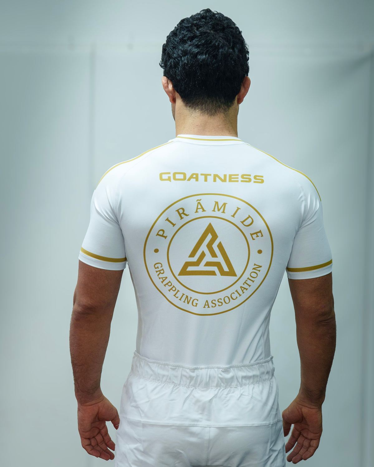 GOATNESS Pirámide Rashguard edición limitada blanca con detalles dorados